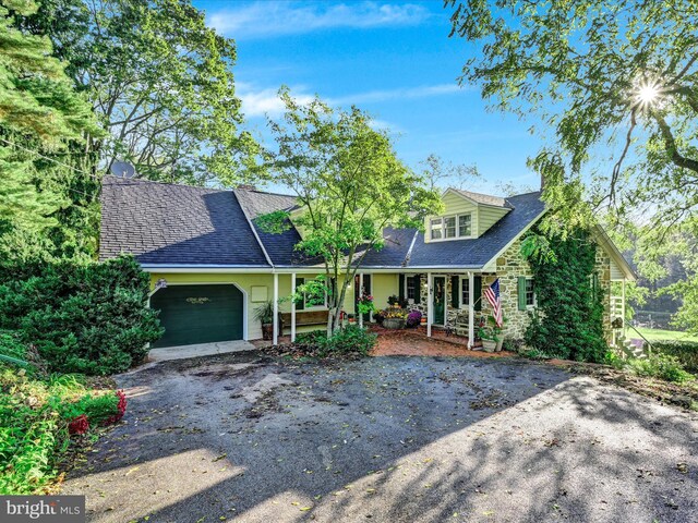 1414 Little Ln, Seven Valleys, PA 17360 - view of front facade featuring driveway, stone siding, an attached garage, a shingled roof, and covered porch