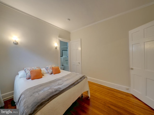 bedroom with hardwood / wood-style floors and crown molding