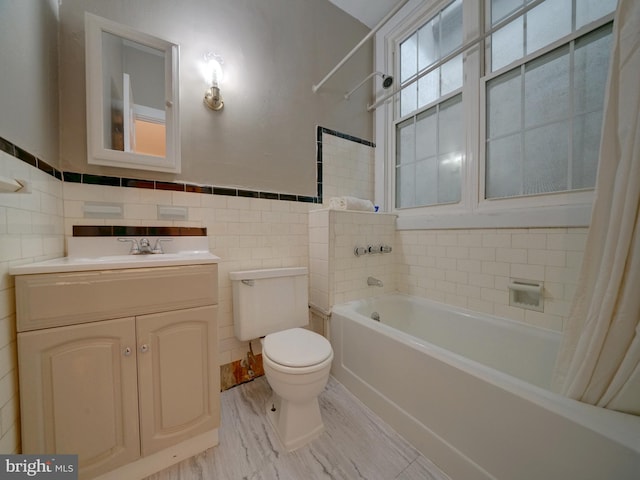 full bathroom with tile walls, vanity, toilet, and shower / bath combo with shower curtain