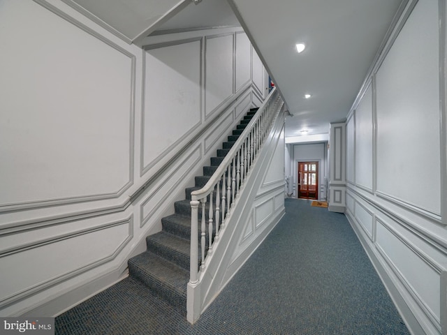 stairs with carpet floors and crown molding