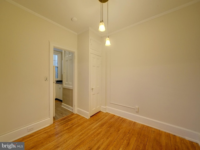 unfurnished room with ornamental molding and light hardwood / wood-style floors