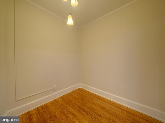 empty room with crown molding and hardwood / wood-style floors