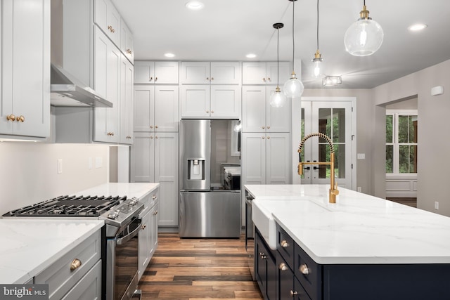 kitchen with a center island, hanging light fixtures, appliances with stainless steel finishes, dark hardwood / wood-style flooring, and light stone countertops