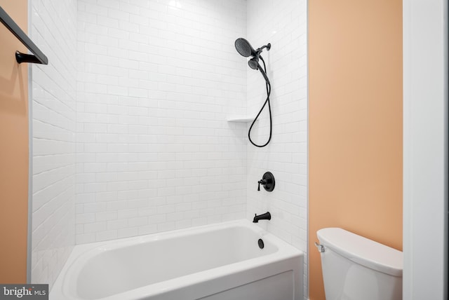 bathroom featuring tiled shower / bath combo and toilet