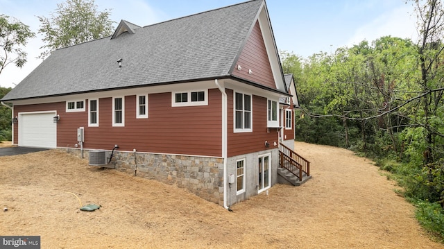 view of home's exterior featuring a garage and central air condition unit