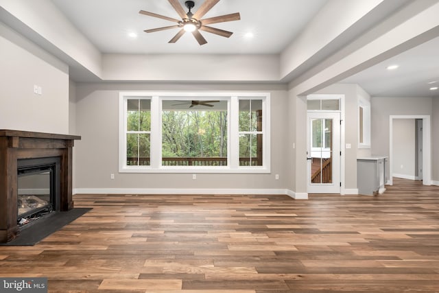 unfurnished living room with ceiling fan and hardwood / wood-style floors