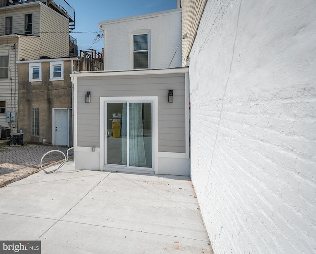 view of exterior entry featuring a patio area and cooling unit