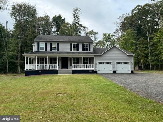 view of front of house featuring covered porch, a front yard, and a garage