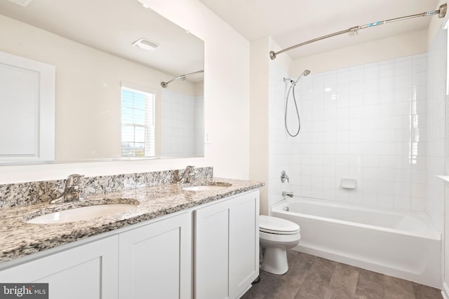 full bathroom featuring tiled shower / bath, toilet, and vanity