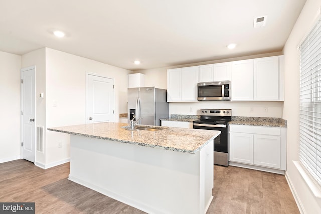 kitchen with white cabinetry, a kitchen island with sink, light hardwood / wood-style floors, and stainless steel appliances