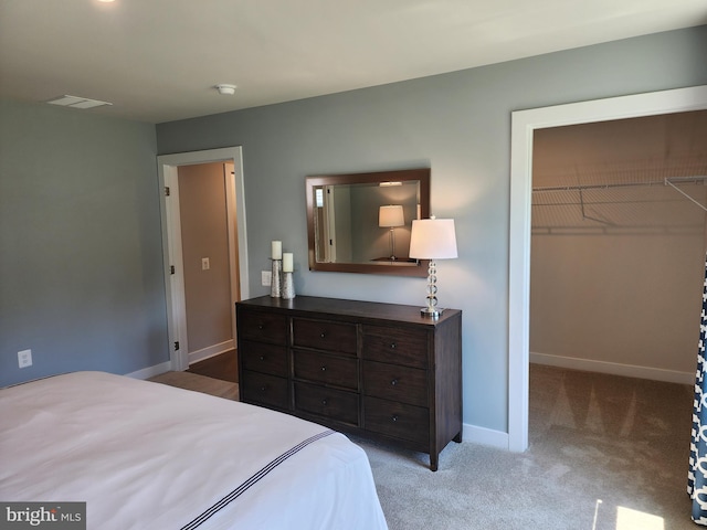 carpeted bedroom with a closet and a walk in closet