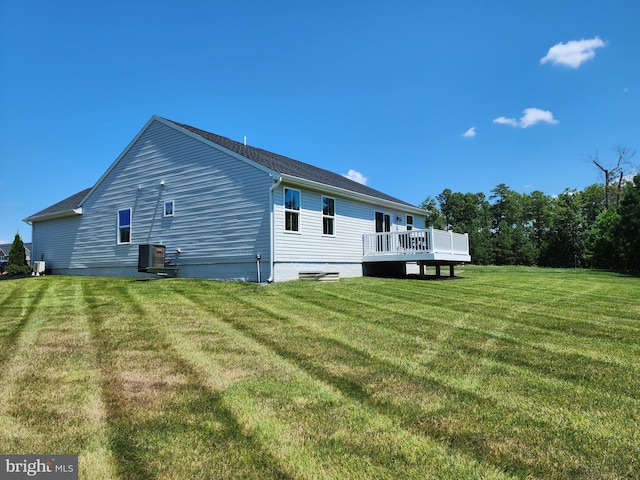 back of property with cooling unit, a yard, and a deck