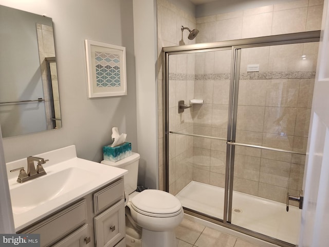 bathroom featuring vanity, a shower with shower door, toilet, and tile patterned flooring