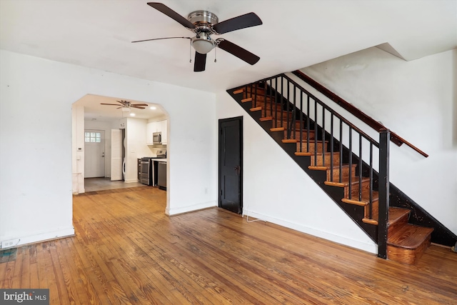 stairs featuring hardwood / wood-style floors and ceiling fan