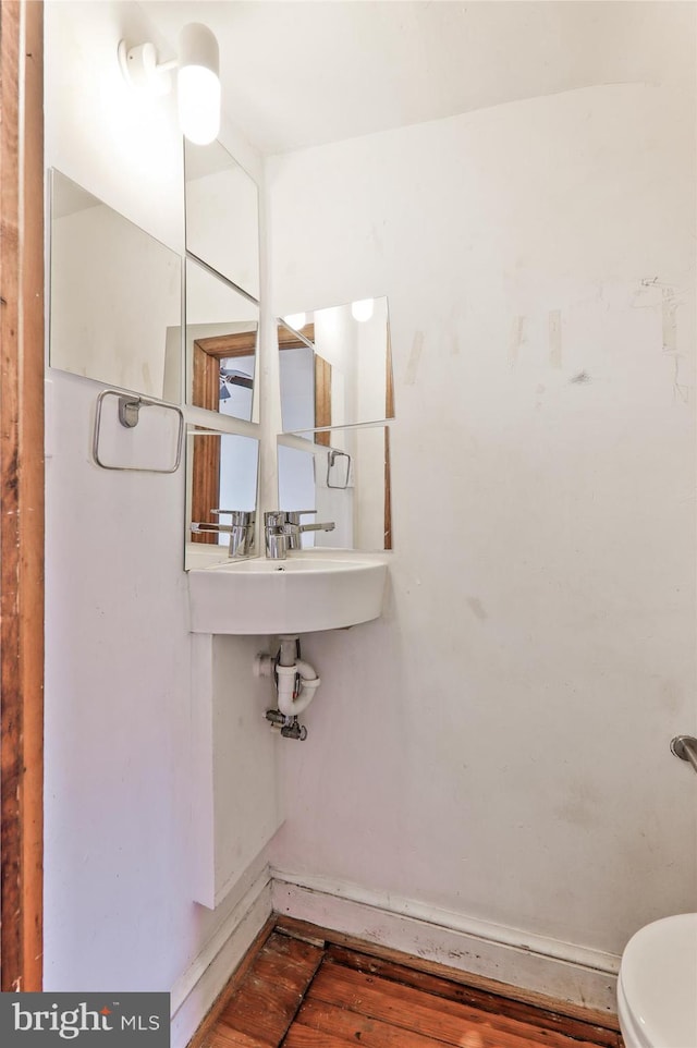 bathroom with hardwood / wood-style flooring and toilet