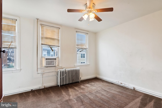 carpeted spare room with ceiling fan, radiator, and cooling unit