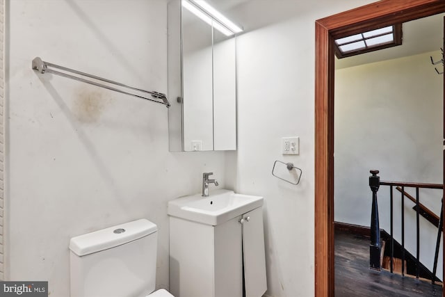 bathroom with wood-type flooring, vanity, and toilet