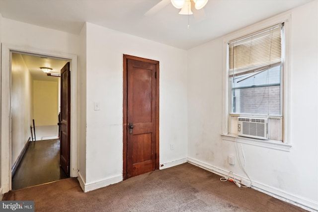 unfurnished bedroom featuring cooling unit, dark carpet, and ceiling fan