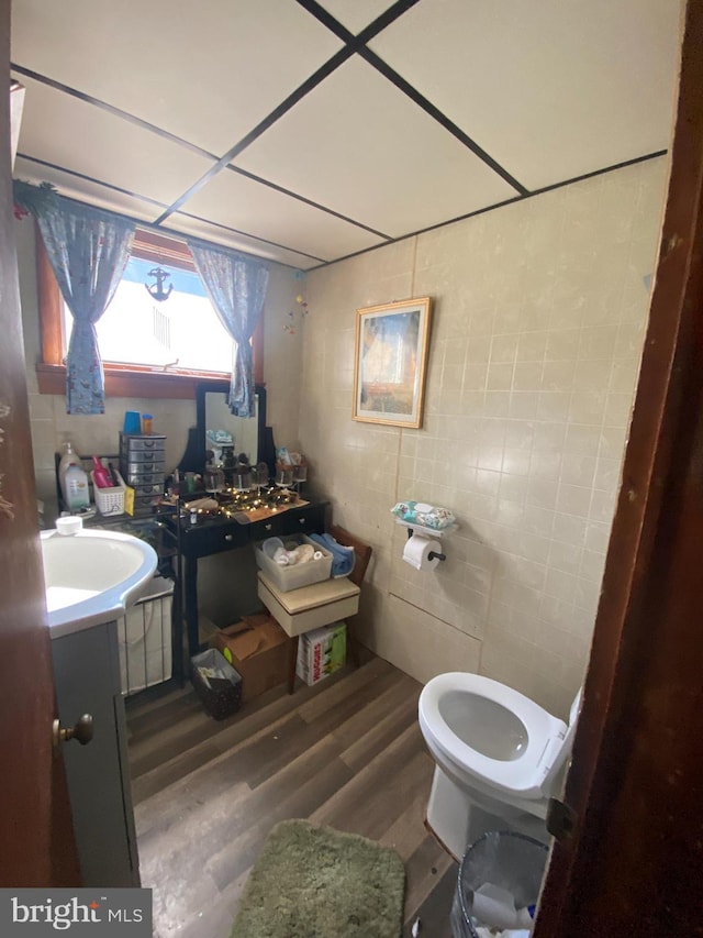 bathroom featuring hardwood / wood-style floors, vanity, toilet, and tile walls