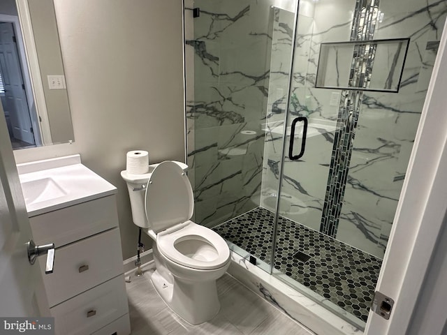 bathroom featuring vanity, toilet, and a shower with door