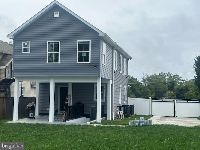 rear view of house with a patio and a yard