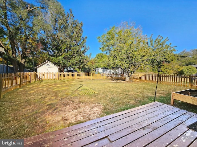 view of yard featuring a storage unit and a deck