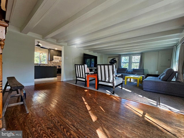 living room with dark wood-type flooring, beam ceiling, and sink