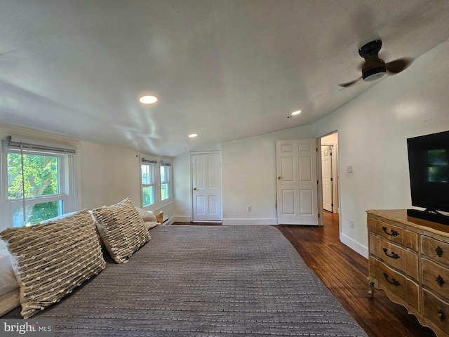 bedroom with multiple windows, vaulted ceiling, dark wood-type flooring, and ceiling fan