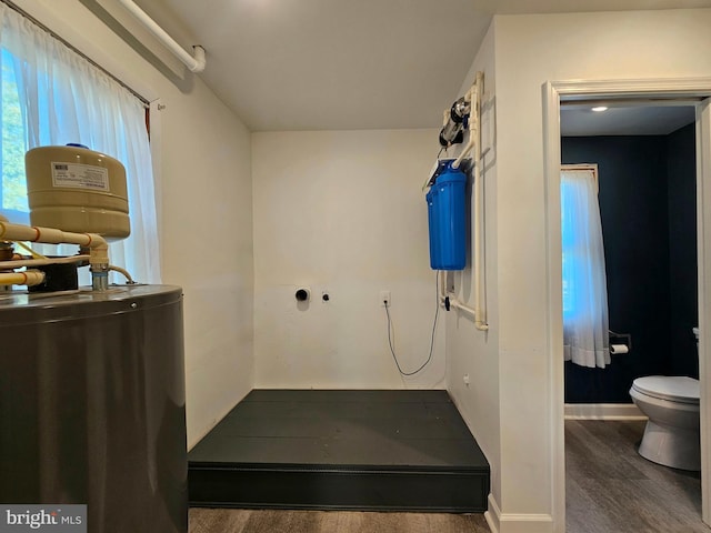 bathroom featuring water heater, wood-type flooring, and toilet