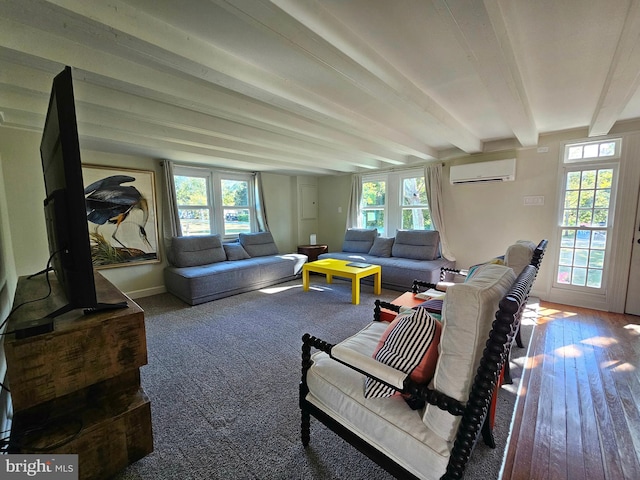 living room featuring beamed ceiling, plenty of natural light, and a wall unit AC