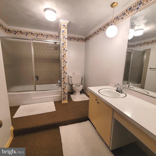 full bathroom with ornamental molding, vanity, toilet, and combined bath / shower with glass door