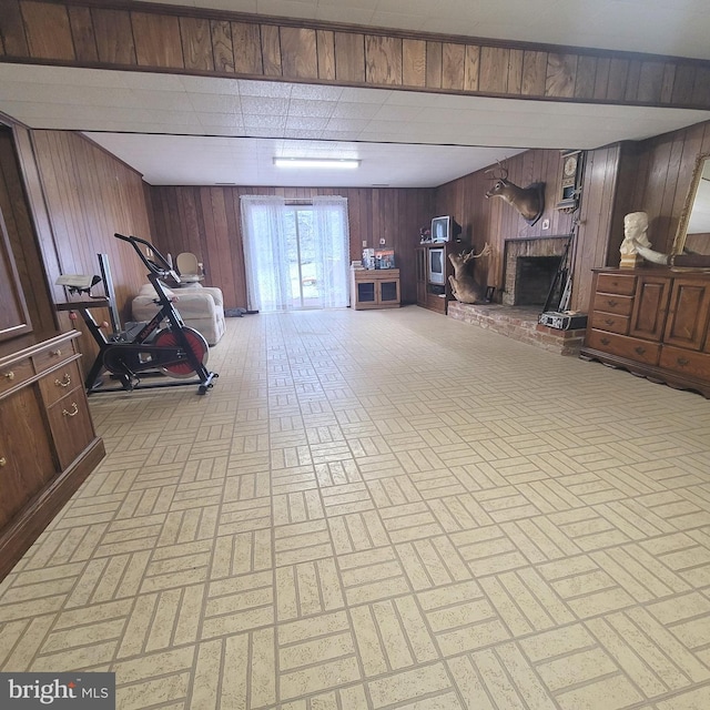 basement with a brick fireplace and wooden walls