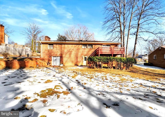 snow covered house featuring a wooden deck