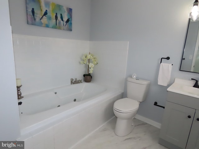 bathroom with tiled tub, vanity, and toilet