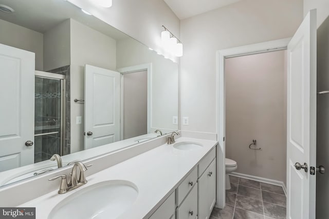 bathroom featuring vanity, toilet, a shower with door, and tile patterned floors