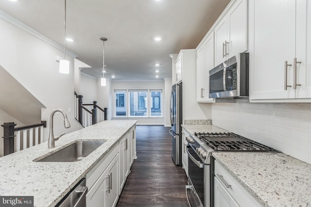 kitchen with dark hardwood / wood-style floors, sink, white cabinets, appliances with stainless steel finishes, and decorative light fixtures