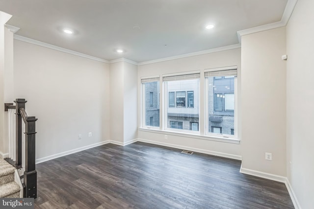 spare room featuring dark hardwood / wood-style floors and ornamental molding