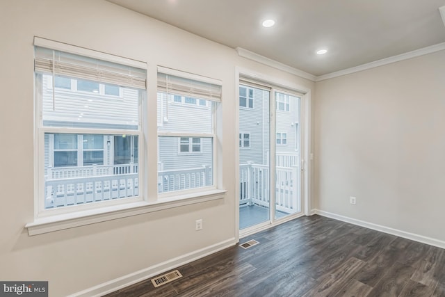 empty room with ornamental molding, dark hardwood / wood-style flooring, and plenty of natural light