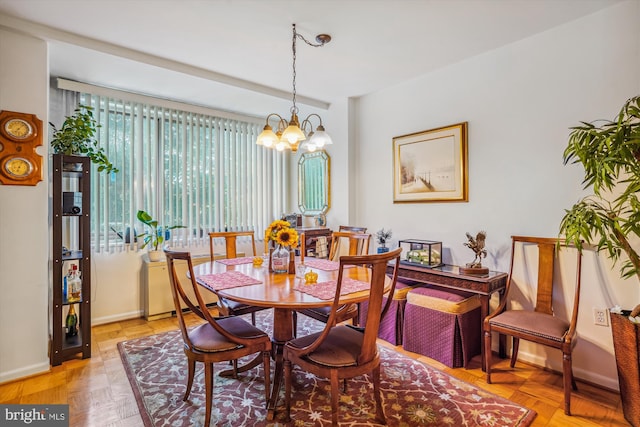 dining space featuring light parquet flooring and an inviting chandelier