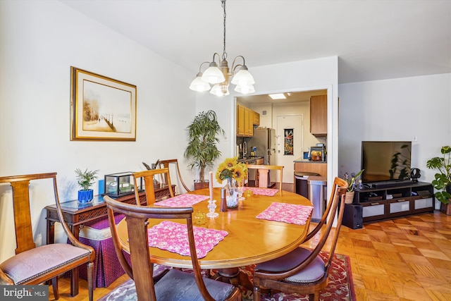 dining area featuring light parquet floors and a chandelier