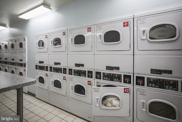 laundry area featuring stacked washer / dryer, independent washer and dryer, and light tile patterned floors