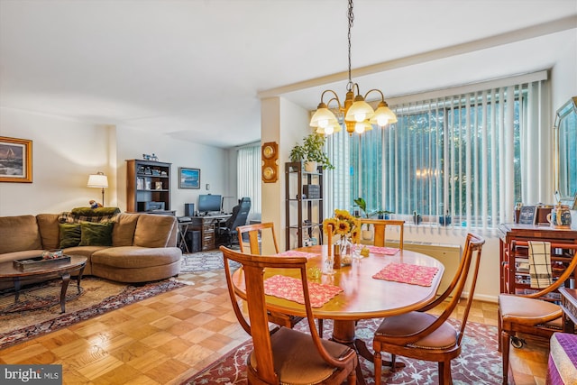 dining area featuring a chandelier and light parquet floors