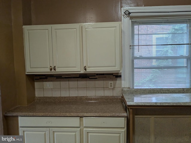 kitchen featuring backsplash and white cabinetry