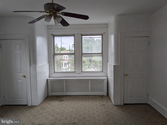 interior space featuring ceiling fan and radiator heating unit