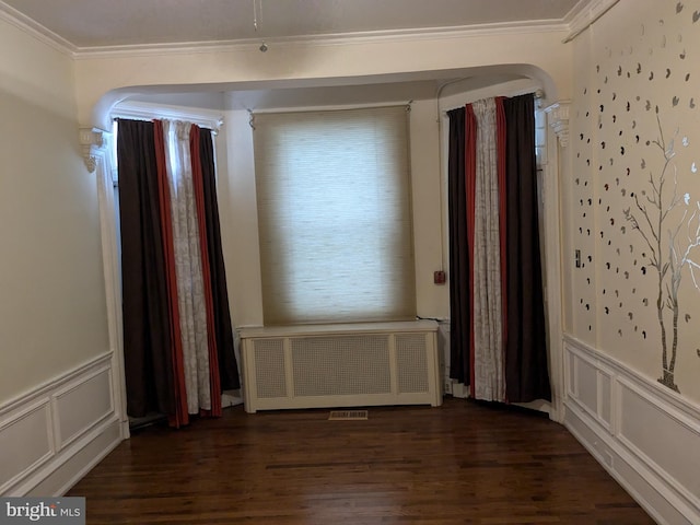 spare room with ornamental molding, dark hardwood / wood-style floors, and radiator heating unit