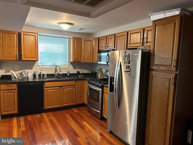 kitchen with appliances with stainless steel finishes, sink, and dark wood-type flooring