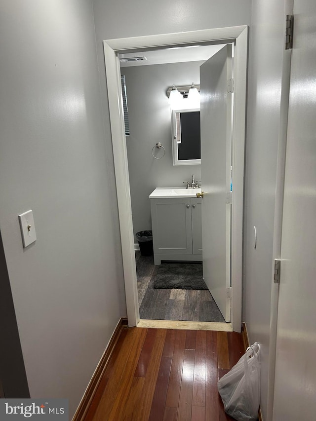 bathroom featuring toilet, vanity, and hardwood / wood-style floors