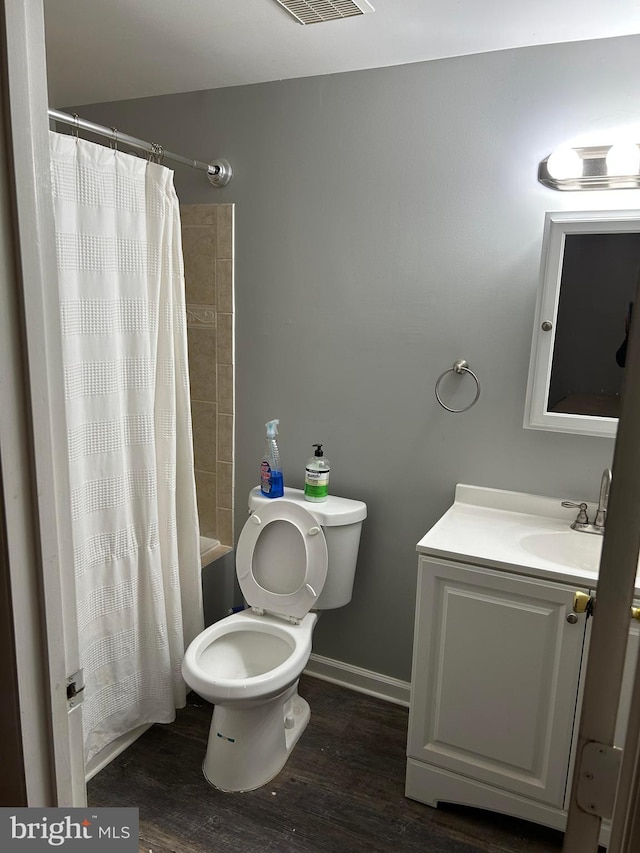 full bathroom with shower / bath combo with shower curtain, wood-type flooring, vanity, and toilet