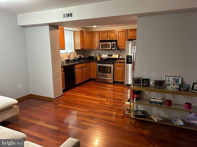 kitchen with sink, stainless steel appliances, and dark wood-type flooring