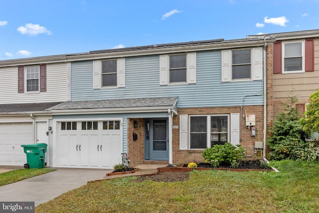 multi unit property with a garage and a front yard